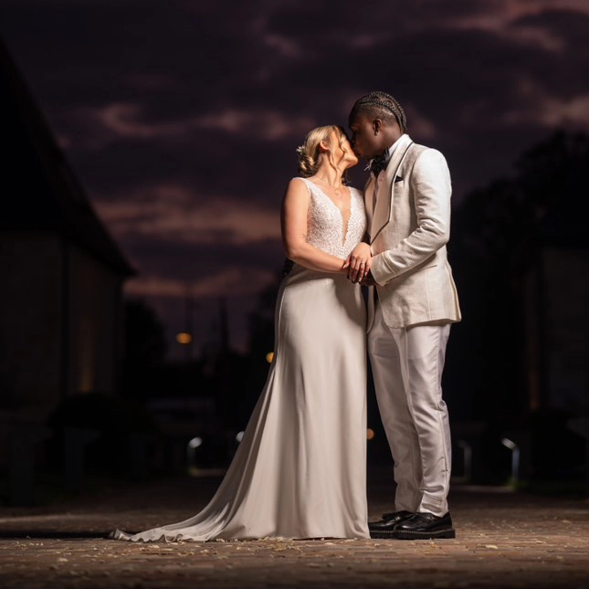 Couple de mariés face à face sous un ciel nocturne, ambiance romantique et lumière dramatique — wedding planner mari-on.fr